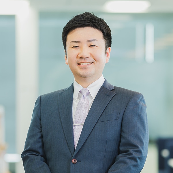 スーツを着た男性自動的に生成された説明